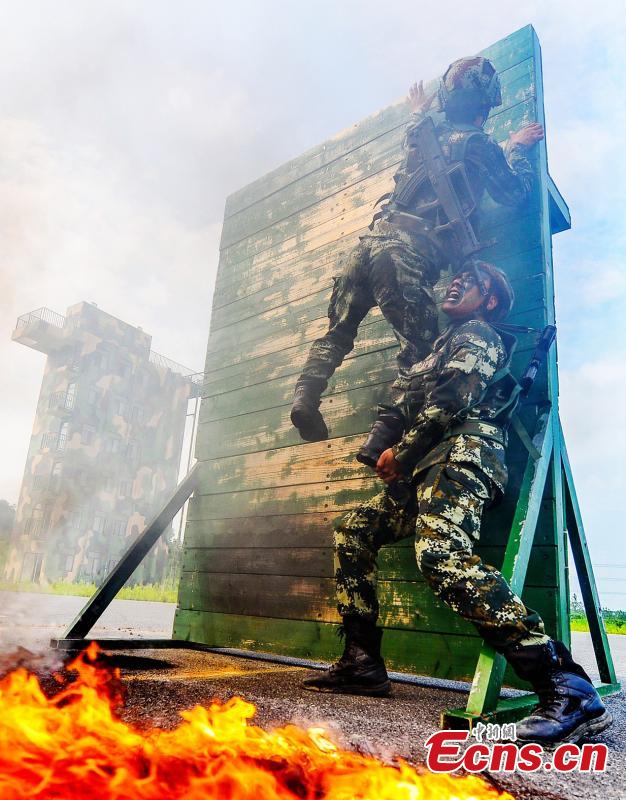 Armed police officers receive intensive training as temperatures hit 35 degrees centigrade in Xuancheng City, East China’s Anhui Province, July 12, 2018. The one-week training included skills in search and rescue in a mountain setting, shooting, and swimming across a river in combat gear. (Photo: China News Service/Ye Jingwen)