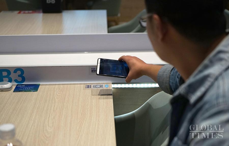 A customer scans a QR code so as to order his food. (Photos: Yang Hui/GT)
Diners at the China International Import Expo get to participate in a new dining experience. It’s as easy as sitting down and ordering through your phone. A few minutes later, a robot brings your food to your table and says, “Enjoy your meal.” The restaurant robot 2.0 introduces a new retailing technology combined with the dining scene.
