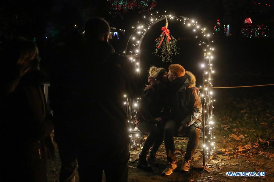 A couple pose for photos under a light decoration during the \