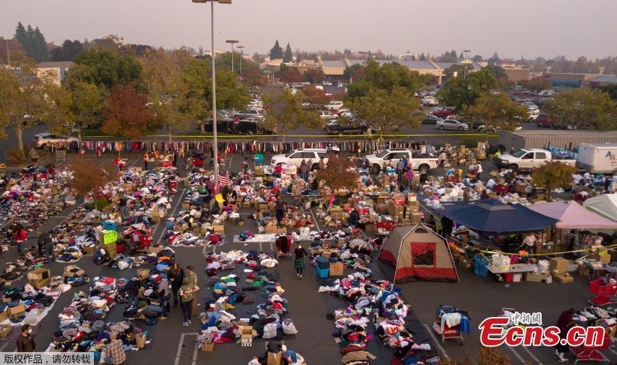 Fire evacuees sift through a surplus of donated items in a parking lot in Chico, California on November 17, 2018. More than 1,000 people remain listed as missing in the worst-ever wildfire to hit the US state. (Photo/Agencies)