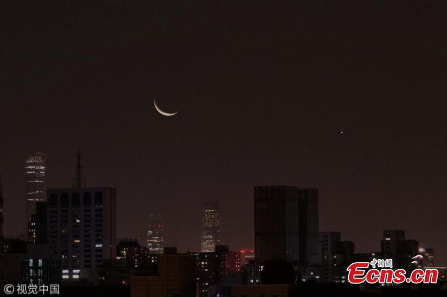 The moon hangs out nest to Venus in the sky of Beijing on Tuesday night, December 4, 2019. The crescent moon was just 3.6 degrees from Venus by twilight, appearing right next to each other to the naked eye. (Photo/IC)